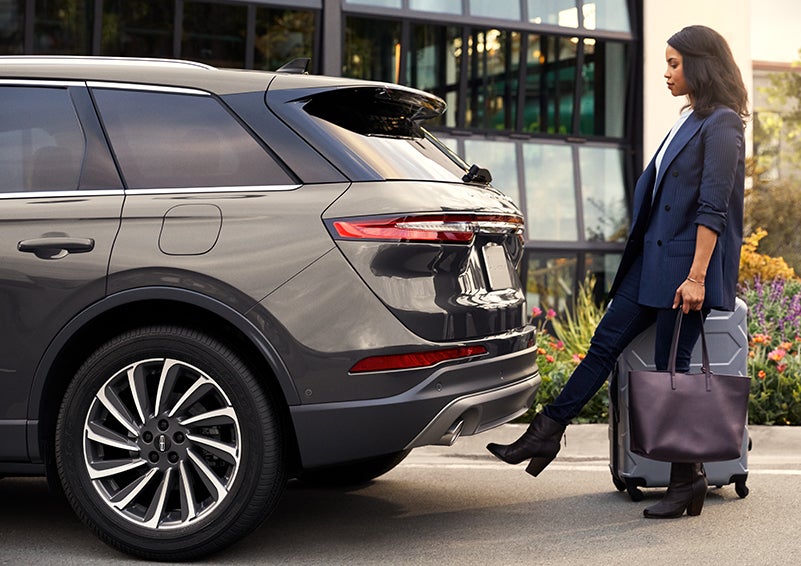 A woman with her hands full uses her foot to activate the available hands-free liftgate. | Gates Ford Lincoln in Richmond KY