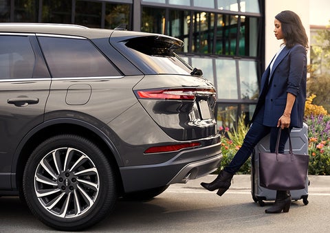 A woman with her hands full uses her foot to activate the available hands-free liftgate. | Gates Ford Lincoln in Richmond KY