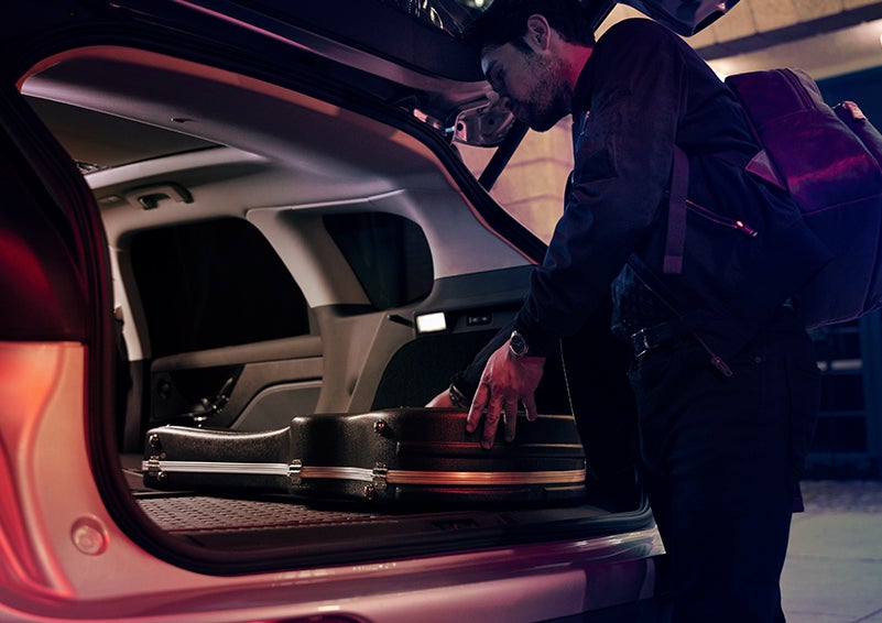 A man is shown loading cargo into the rear of a 2024 Lincoln Corsair® SUV with the second-row seats folded flat. | Gates Ford Lincoln in Richmond KY