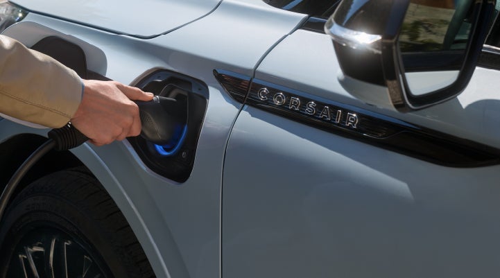 A hand is plugging in a 2026 Lincoln Corsair® Grand Touring Plug-in Hybrid SUV. | Gates Ford Lincoln in Richmond KY